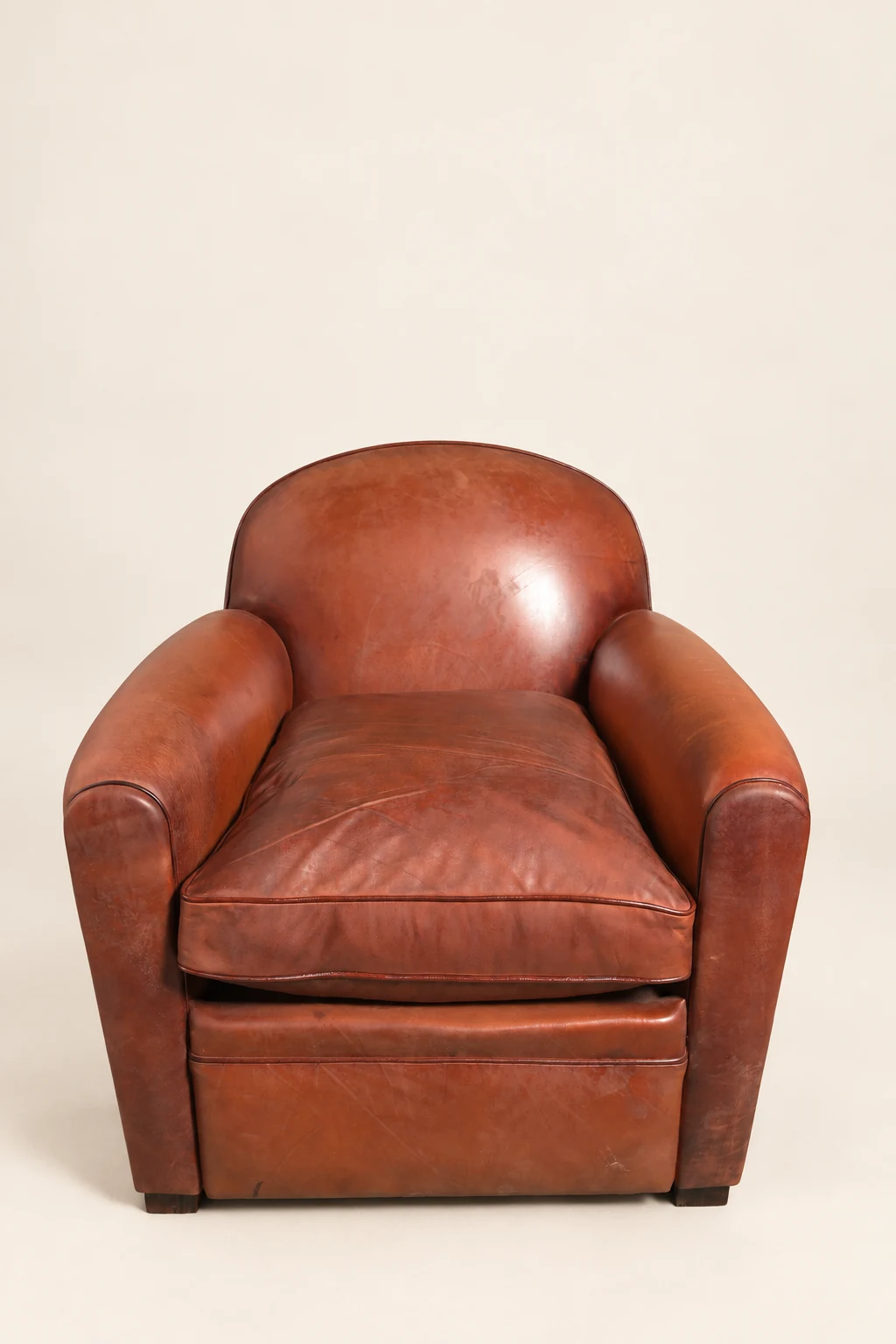 Brown barrel-back leather armchair, front studio view