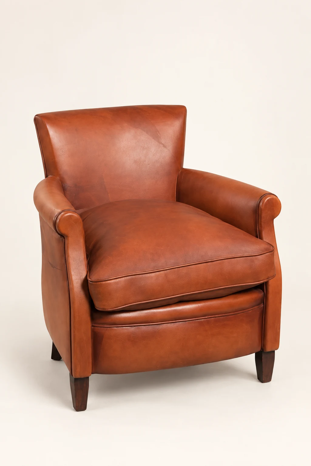 Cognac roll-arm leather armchair, three-quarter studio view